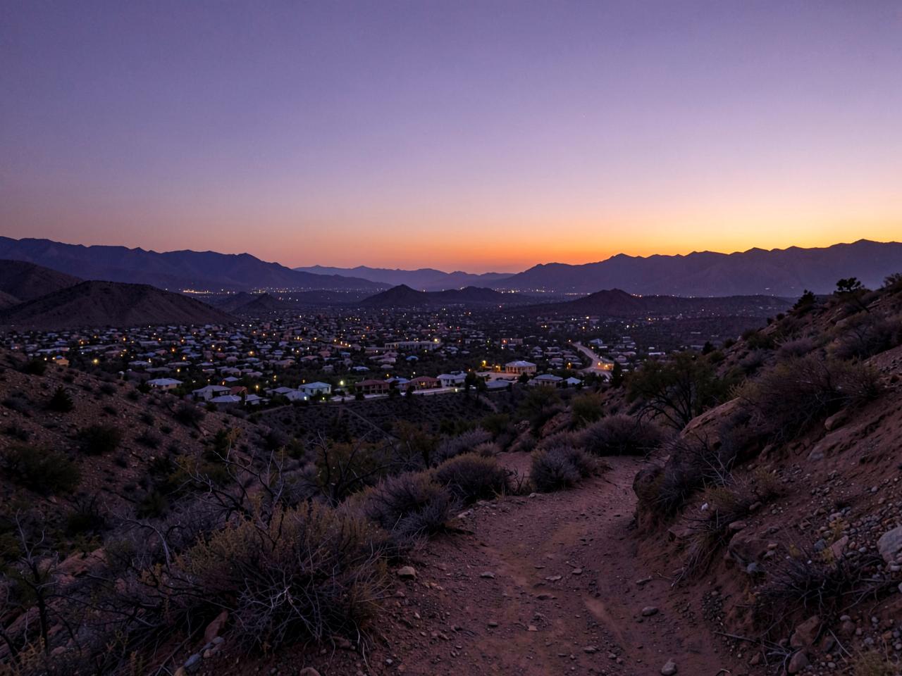 Illustrative photograph of a desert trail above a residential valley at dusk